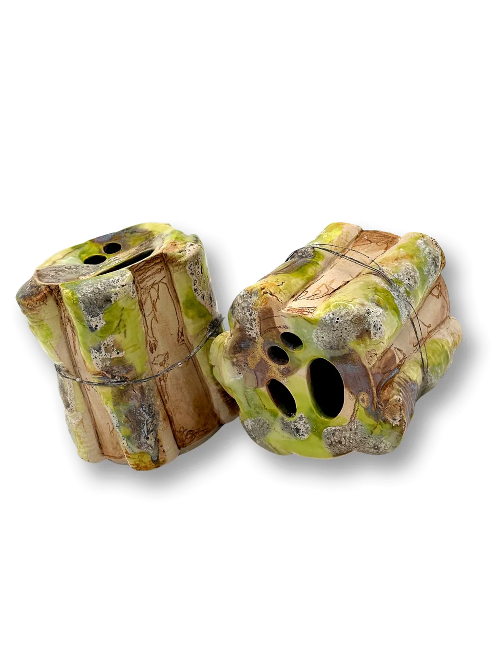 Two carved stoneware tubes with layered green, yellow and grey glazes.