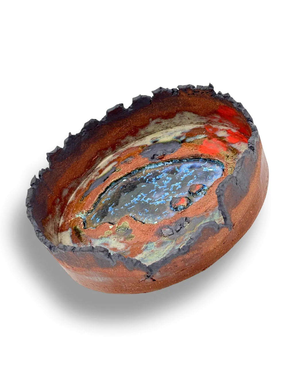 A shallow stoneware bowl with a red and turquoise crackle glaze and a crusted rim.