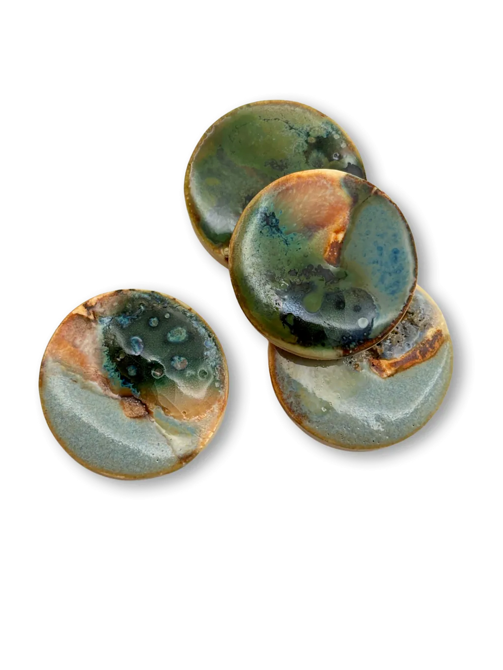 Three small stoneware dishes with pale green and copper glaze, stacked loosely.